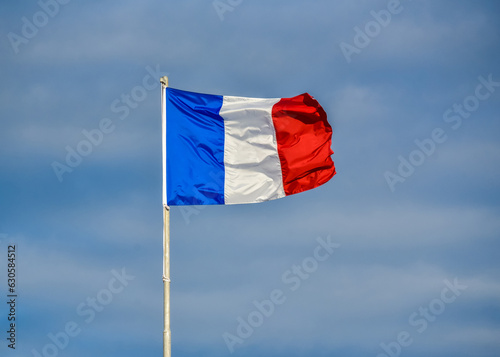 Bandera de Francia ondeando en el viento sobre un cielo azul photo