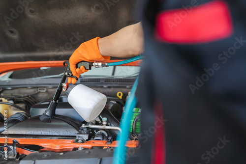Asian male worker's hand cricks gloves using a blower to clean the engine. hand focus
