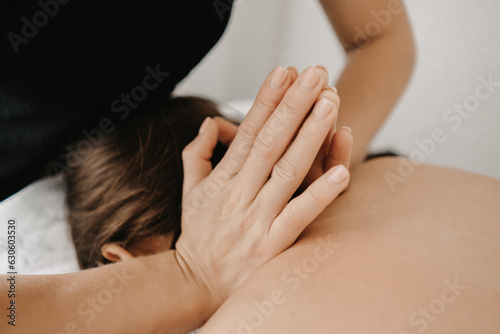Masseur doing a foot massage with candles on background