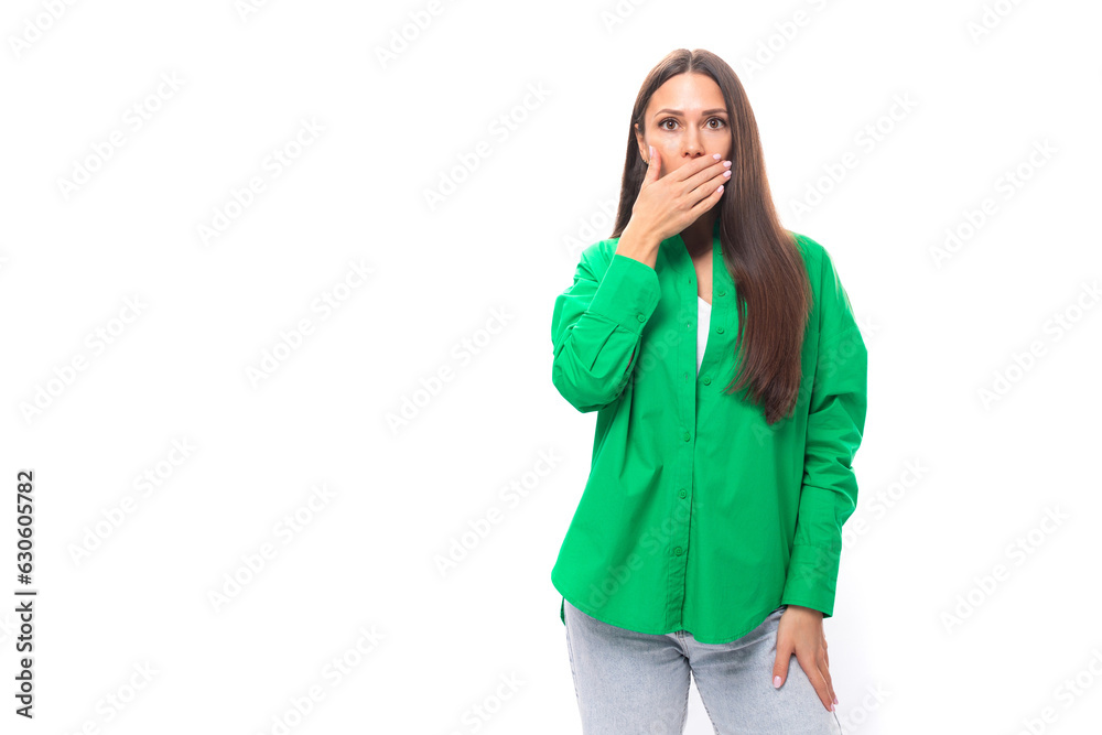 young brown-haired female model with brown eyes in a green shirt is surprised on a white background with copy space for text young brown-haired female model with brown eyes in a green shirt is surprised on a white background with copy space for text