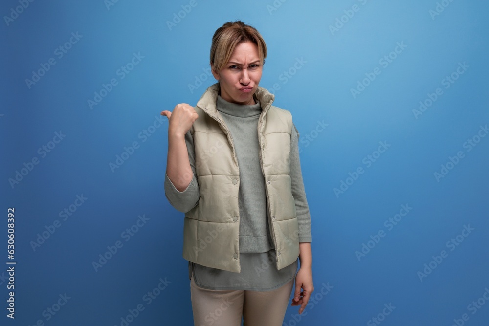 blond indignant young woman shows her hand to the side blond indignant young woman shows her hand to the side