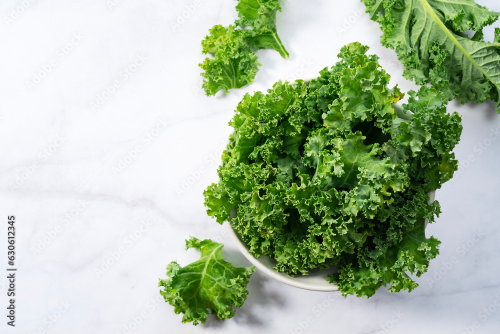 Obraz premium Kale in bowl on marble background. curly kale.