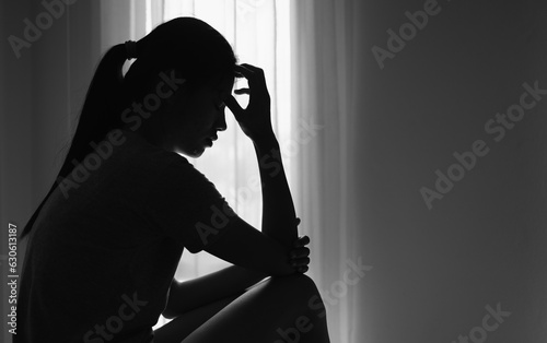 Young  women sitting in dark room feeling pain with life problem.  suffering from husband violence, Stop violence against and sexual abuse women, domestic violence, anti human trafficking. photo
