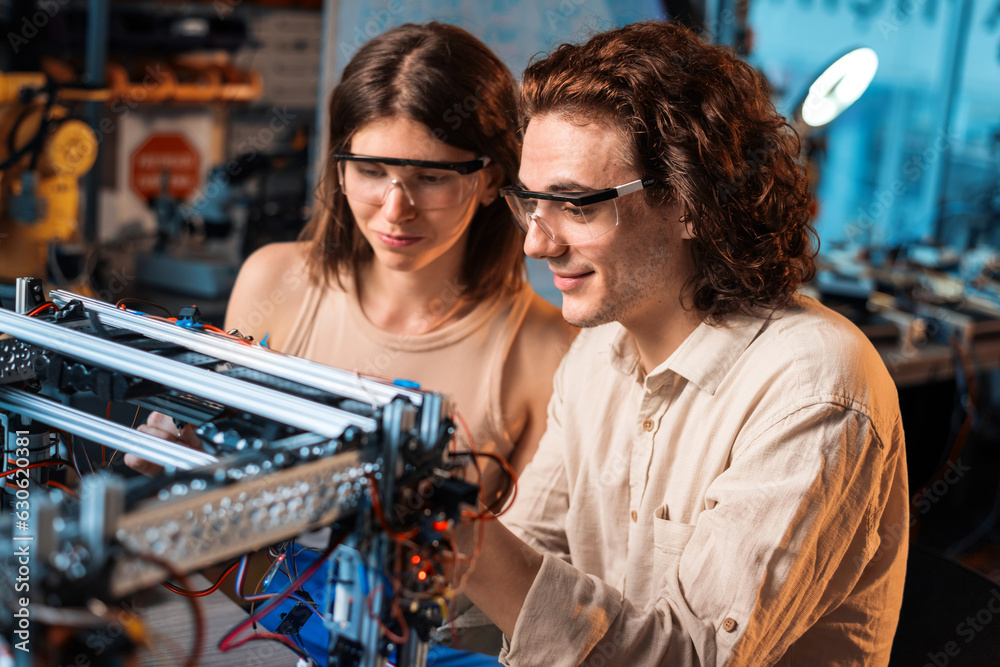 Young man and woman doing experiments in robotics in a laboratory