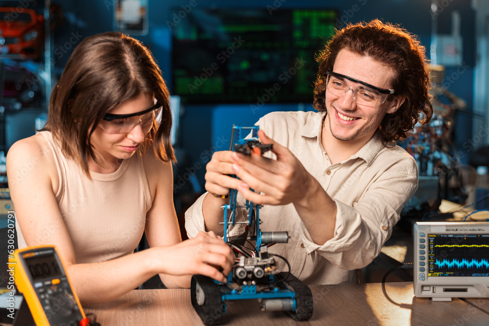 Young man and woman doing experiments in robotics in a laboratory