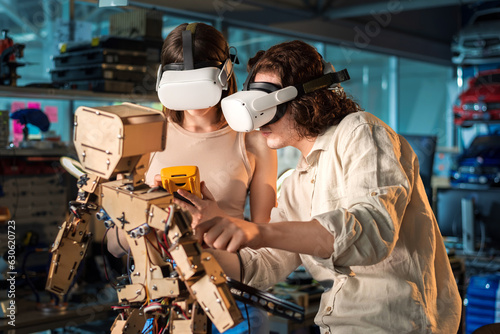 Young man and woman in VR glasses doing experiments in robotics in a laboratory © frimufilms