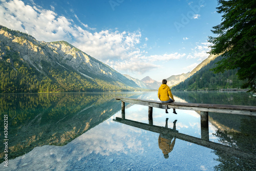 фотография Auszeit genießen in den Bergen, Frau sitzt auf kleinen Steg