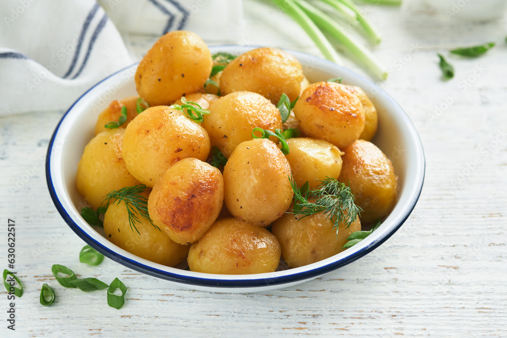 Boiled new or young potatoes with butter, fresh dill and onions in white bowl on white old rustic wooden background. Tasty new boiled potatoes. Top view. Boiled new or young potatoes with butter, fresh dill and onions in white bowl on white old rustic wooden background. Tasty new boiled potatoes. Top view.