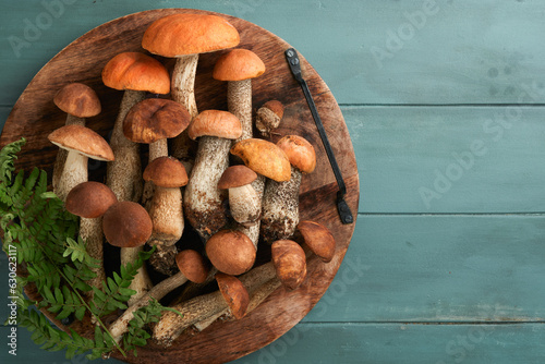 Porcini mushroom or mushroom an orange-cap boletus on old rustic wooden table backgrounds. Organic forest food. Autumn harvest concept. Edible fresh picked mushroom. Copy space. Top view.
