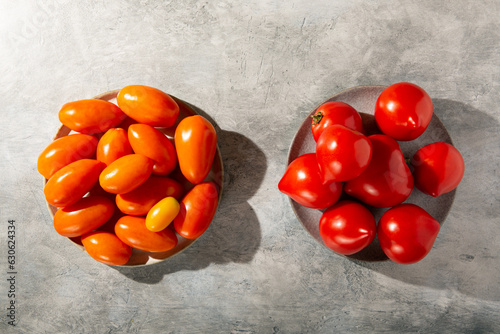 Red and orange tomatoes on gray background. Top view.
