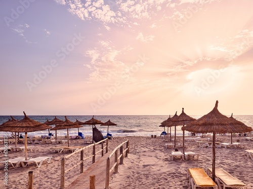 Sunrise over the sea on a beach full of straw umbrellas, Mahdia, Tunisia in Africa © Rastislav
