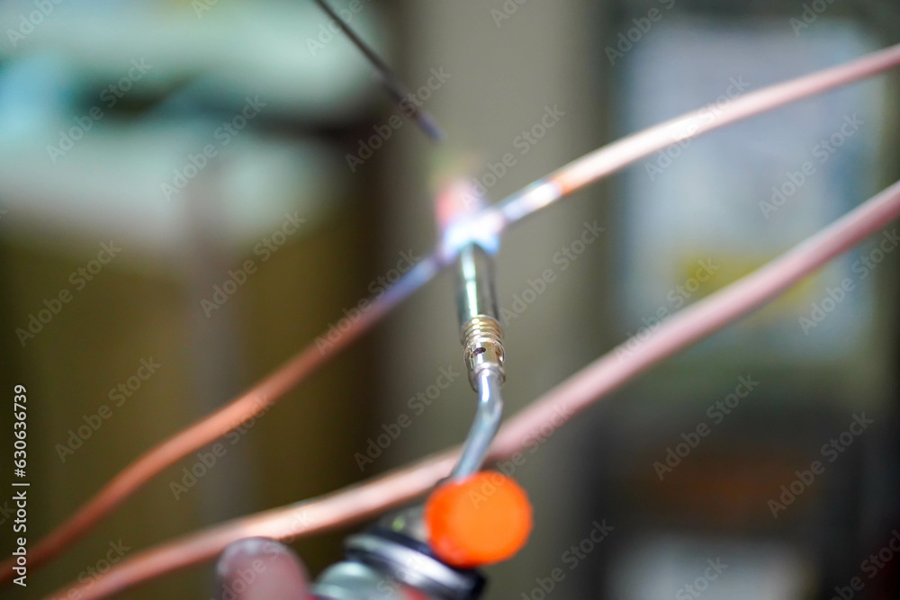Closeup builder using gas welding to connect the refrigerant pipe. Closeup builder using gas welding to connect the refrigerant pipe.
