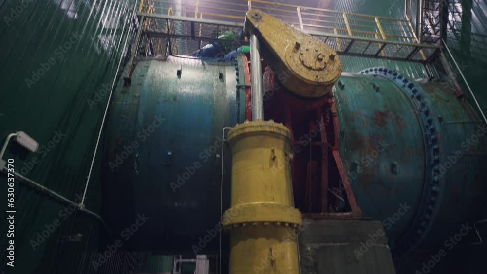 Large iron technical pipe in hydroelectric power plant with gate valve to shut off flow water into turbine. Large iron technical pipe in hydroelectric power plant with gate valve to shut off flow water into turbine.