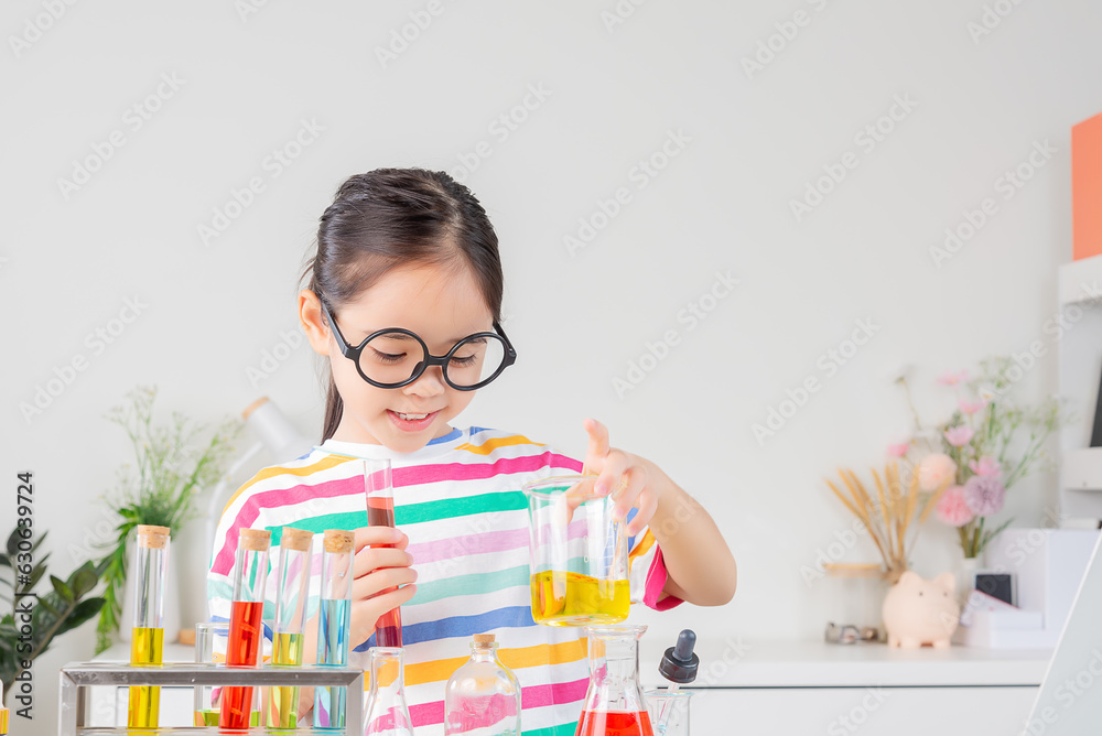 Asian little girl working with test tube science experiment in white classroom Asian little girl working with test tube science experiment in white classroom