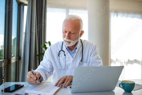 Senior medic connects with a client via video call. Doctor therapist in office, uses a laptop to provide compassionate guidance and explain medical treatment, fostering a sense of trust and support.