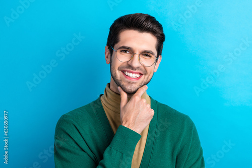 Photo of dreamy smart guy dressed green cardigan eyewear arm chin smiling isolated blue color background