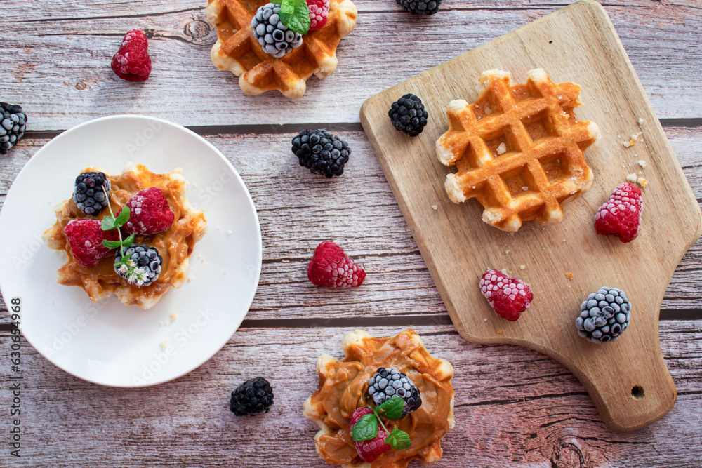Belgian waffles with berries. Morning. On a wooden background Belgian waffles with berries. Morning. On a wooden background