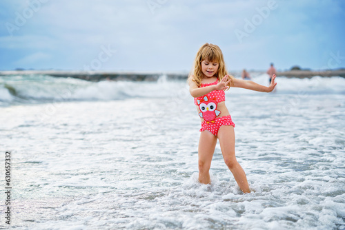 Happy Child, Little Preschool Girl in Swimmsuit Running And Jumping In The Waves During Summer Vacation On Exotic Tropical Beach. Family Journey On Ocean Coast. © Irina Schmidt