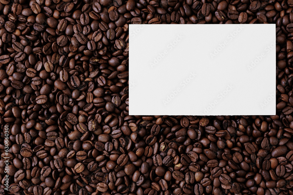 Top view of blank paper card with copyspace on background from coffee beans Top view of blank paper card with copyspace on background from coffee beans