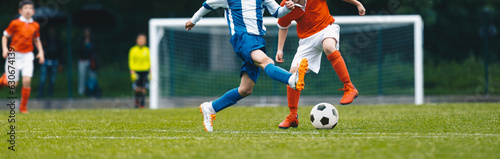 European soccer match between youth teams. Young school boys playing soccer game. Junior competition between players running and kicking soccer ball. Tournament game between red and blue kids\' teams
