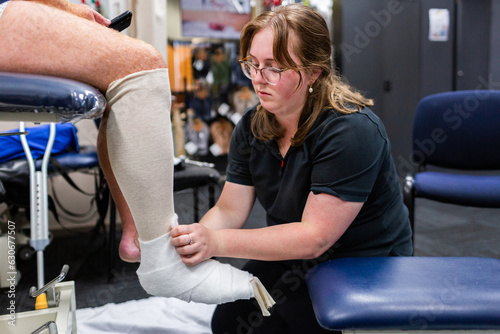 medical professional putting walking cast on leg photo