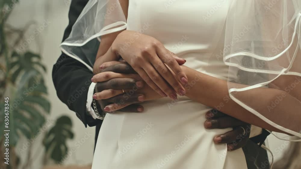 Cropped shot of unrecognizable multiracial newlywed couple holding hands during romantic photoshoot after wedding ceremony Cropped shot of unrecognizable multiracial newlywed couple holding hands during romantic photoshoot after wedding ceremony