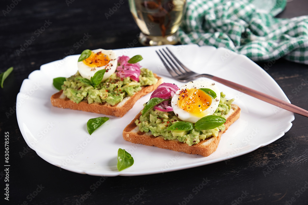 Healthy toast with mashed avocado, boiled eggs, spices and red onions. Delicious breakfast or snack.