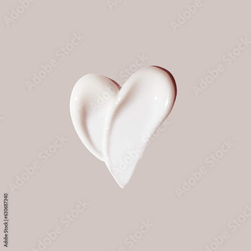 cosmetic smear of cream in the shape of heart on beige background