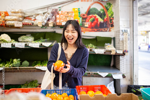 20-something Asian woman shopping buying groceries at a supermarket photo