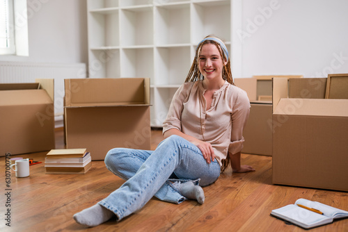 Modern ginger woman with braids moving into new apartment.