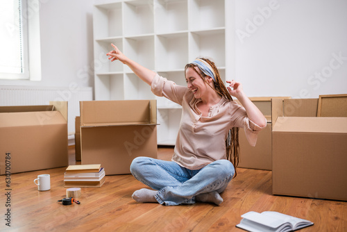 Excited ginger woman with braids moving into new apartment.