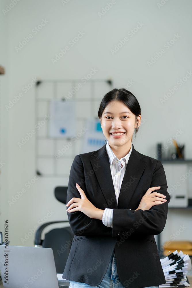 Asian woman standing on front desk while holding coffee cup and looking outside employee in formal suit standing in front of desk smiling in corporate office Asian woman standing on front desk while holding coffee cup and looking outside employee in formal suit standing in front of desk smiling in corporate office