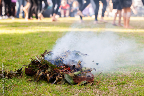 Smoking ceremony at event during aboriginal dance showing burning leaves photo
