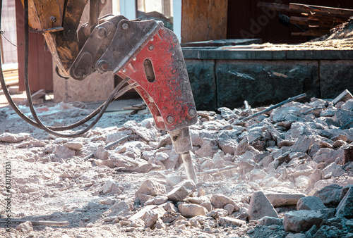 Jackhammer machine breaks concrete in the city.