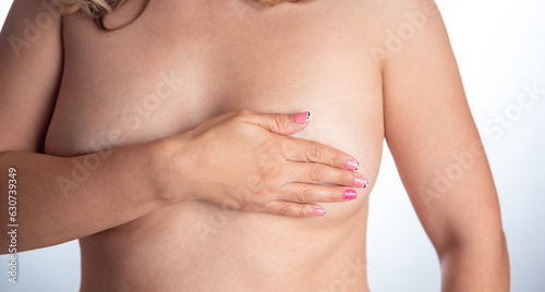 Bare-chested woman performing a breast self-exam. October 19 world day against breast cancer.