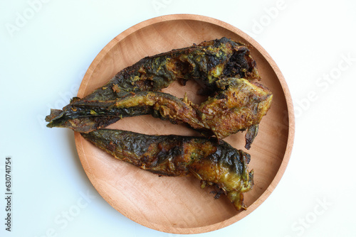 Fried catfish on a wooden plate, isolated on white background photo