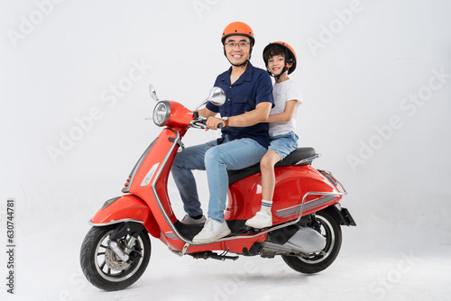 father and son wearing helmets and riding motorbikes