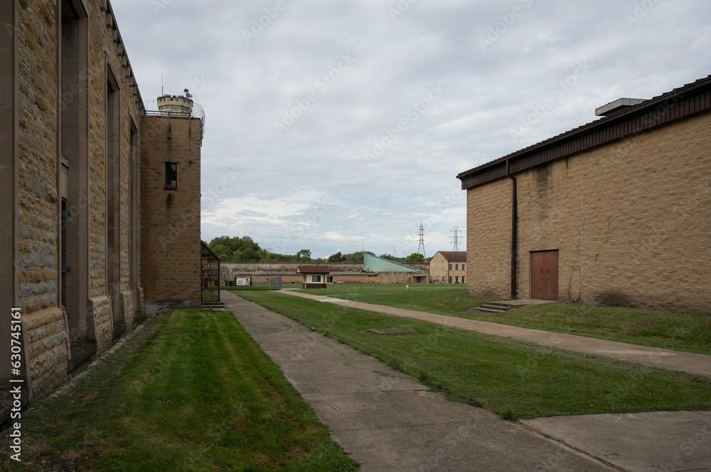 a very long driveway near several brick buildings and a grass field a very long driveway near several brick buildings and a grass field