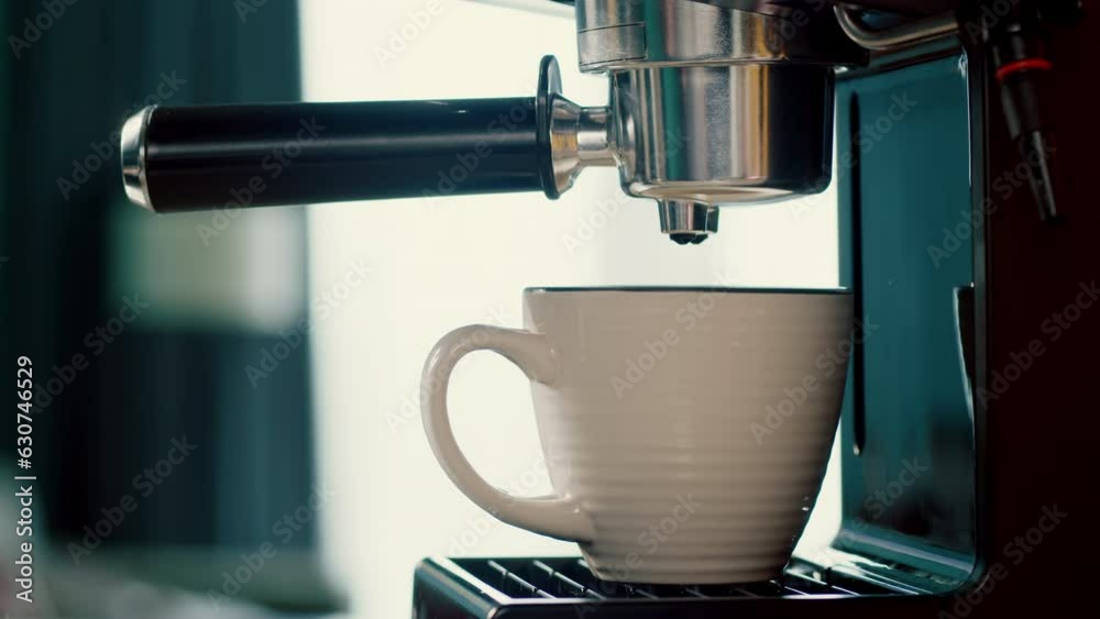 Concept Drinking roasted black coffee in the morning.Pouring coffee stream from machine in cup. Pouring coffee stream from machine in cup. Flowing fresh ground coffee. Home making hot Espresso. 4K