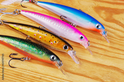 Four minnow wobblers on the background of wood texture.