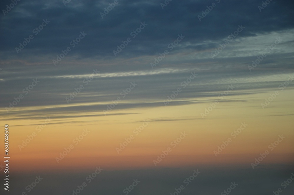 Beautiful natural sunrise, sunset against a dark blue sky with an orange stripe. Abstract background.