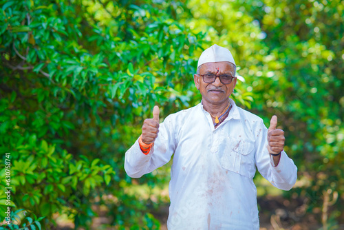 Indian farmer showing thumbs at farm.
