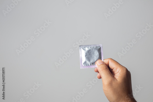 The man's hand confidently grabbed a condom, showing that he prioritizes safety and responsibility in intimate situations.
