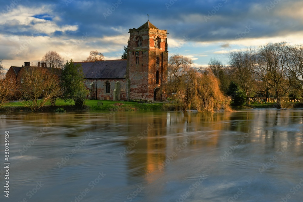Tranquil view of the Church at Atcham, Shropshire, England, reflected in the River Severn