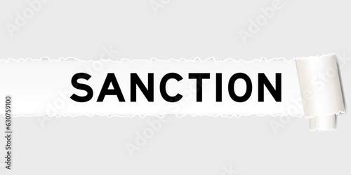 Ripped gray paper background that have word sanction under torn part