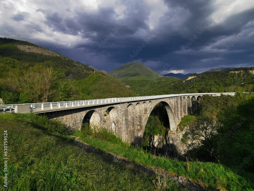 Alpes, le viaduc de l'ancien chemin de fer sous la menace de l'orage