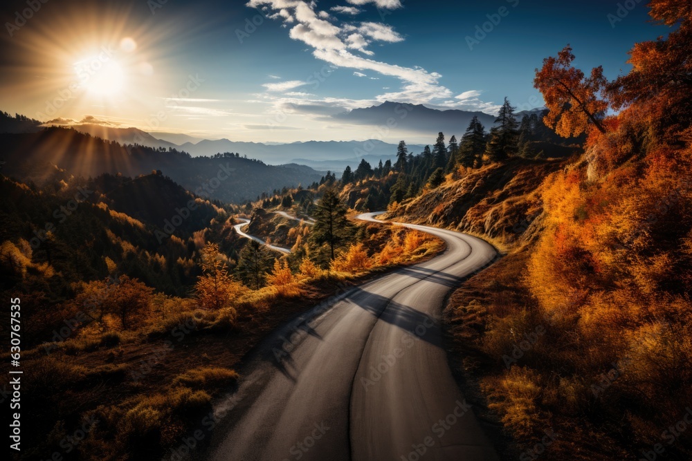 Fototapeta premium meandering road in the mountains through autumn forest, sunset. 