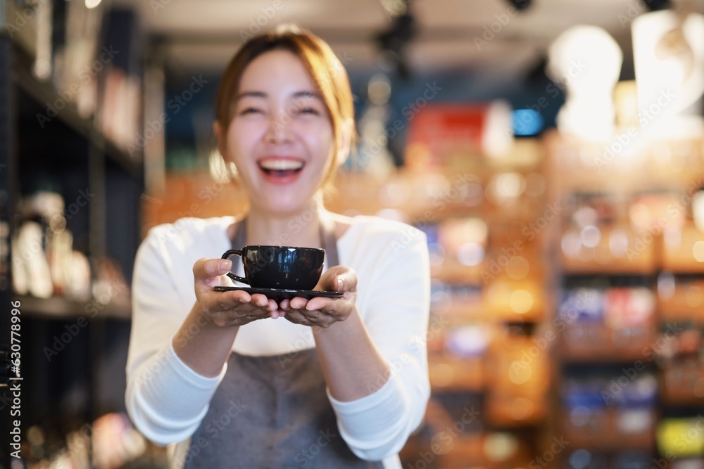 Cheerful woman making a coffee cup in cafe,Barista holding a cup of hot coffee for the first Morning.