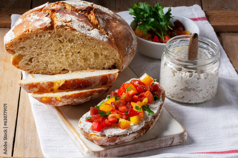 Bruschetta from homemade bread with cottage cheese and sprat pate and tomatoes on a wooden background. Rustic style.
