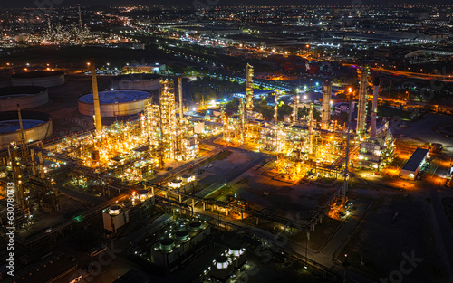 Aerial view of the petrochemical, oil and gas industry. Industrial field, oil refinery storage tanks and steel pipelines at night, ecology and health.
